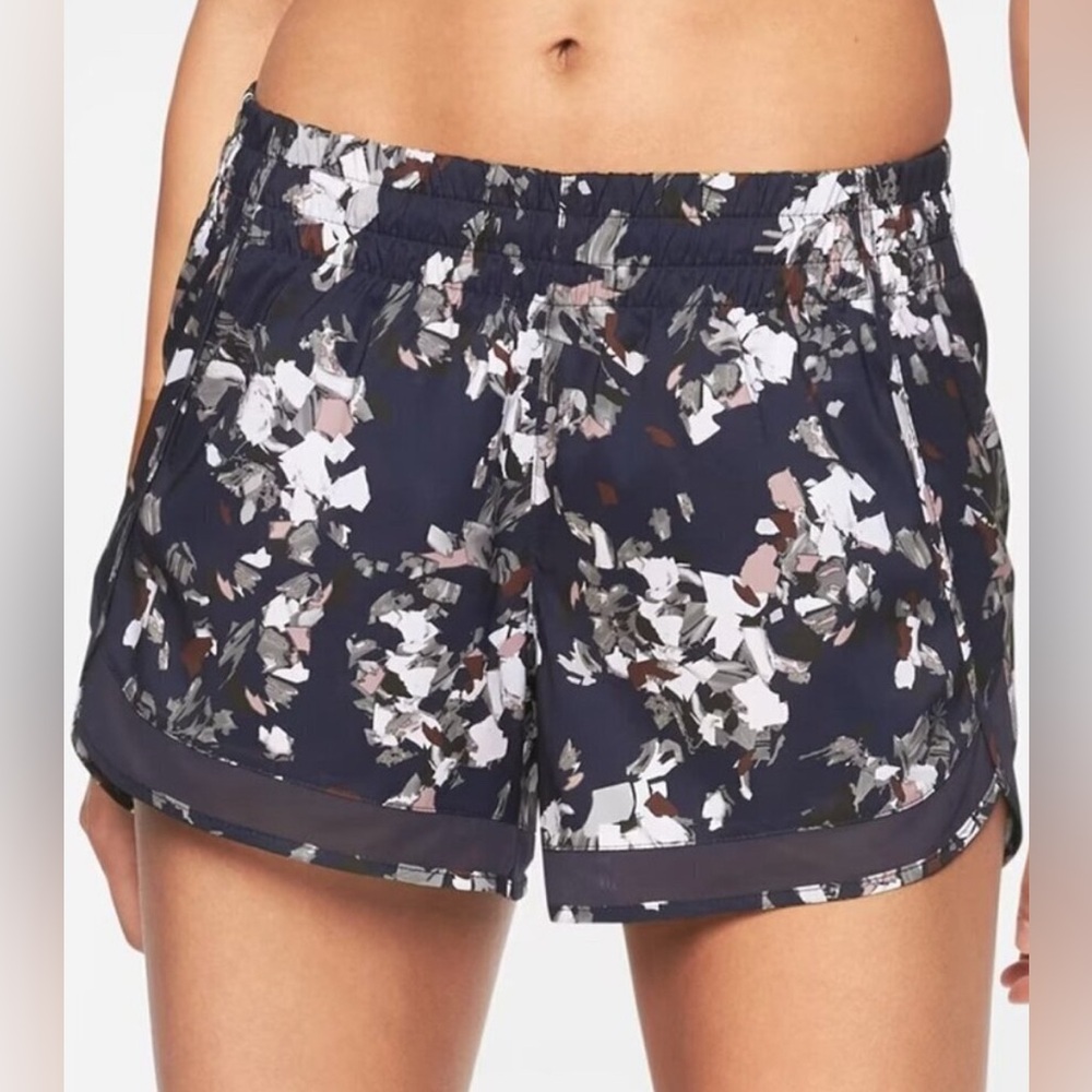 ATHLETA 4” navy floral running shorts size Medium. Mesh hem. Side zip pocket.